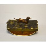 A COLD PAINTED BRONZE OF A DACHSHUND, mounted on a brass and wooden blotter, approximately 12cm