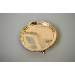 A GOLDSMITHS AND SILVERSMITHS SILVER CARD TRAY, of circular form on three feet, London 1908,