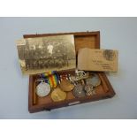 A HINGED WOODEN BOX CONTAINING A GROUP OF FOUR MEDALS, spanning both WWI and WWII British War and