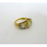 AN 18CT GOLD OPAL AND DIAMOND RING, with three large oval opals to a trio of brilliant cut