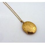 A 9CT GOLD LOCKET AND CHAIN, of oval shape with flower engraving to the fine link chain, length