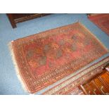 A RED GROUND RUG, approximate size 172cm x 132cm
