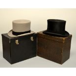 TWO BOXED TOP HATS, the first a grey top hat with a black band, the second a black silk top hat from