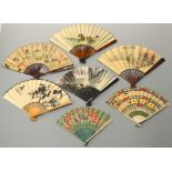 A COLLECTION OF SEVEN PAPER FANS, to include a calendar fan