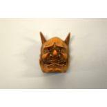 A JAPANESE BOXWOOD MASK NETSUKE, depicting Hannya, the demon carved with open mouth and upright