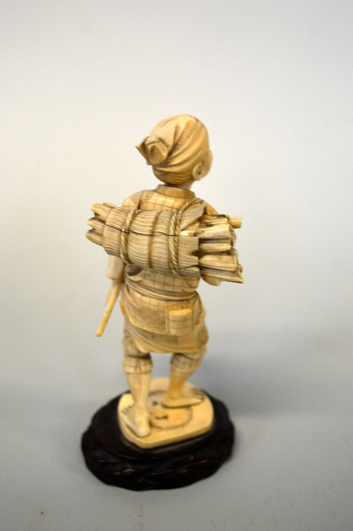 A JAPANESE IVORY OKIMONO MAN CARRYING STICKS, on hardwood base, approximate height 19cm - Image 2 of 2