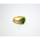 AN EMERALD AND DIAMOND RING, the pear-drop shape emerald flanked by three brilliant-cut diamonds,