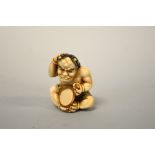 A JAPANESE IVORY NETSUKE, depicting Kyogen looking into a mirror, signed to base