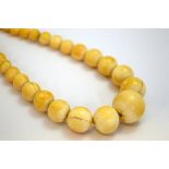 A STRAND OF IVORY BEADS, comprising of thirty-three graduating ivory beads, length 45cm