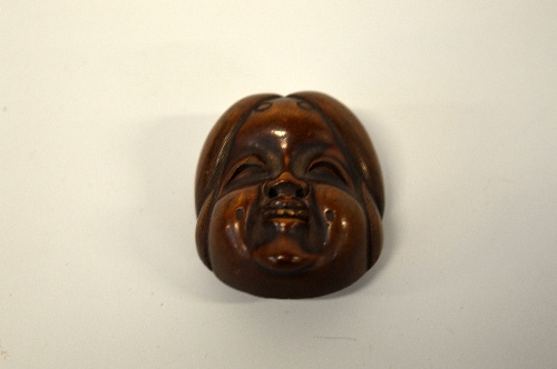 A JAPANESE BOXWOOD MASK NETSUKE, depicting Kyogen (comic mask) of Hyottoka, signed to the rear