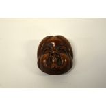 A JAPANESE BOXWOOD MASK NETSUKE, depicting Kyogen (comic mask) of Hyottoka, signed to the rear