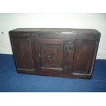 AN 18TH CENTURY CARVED OAK HANGING CUPBOARD, with central door flanked by panels carved with diamond