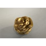 A JAPANESE IVORY NETSUKE, Meiji period, in the shape of a seated Ape fighting over a banana with a