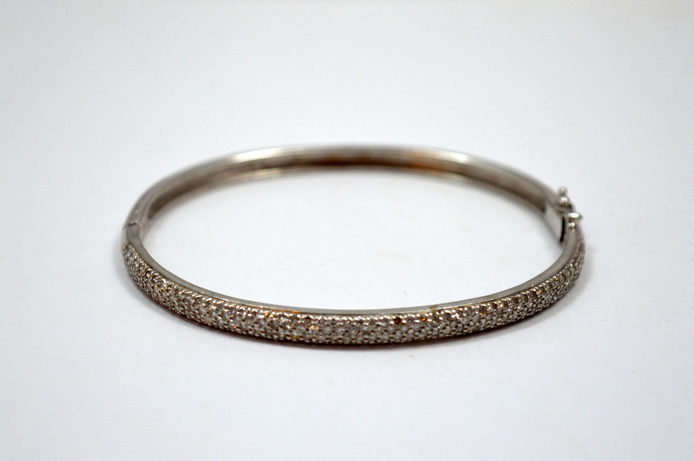 A DIAMOND BANGLE, with one half of the bangle with single cut diamonds to the hinged further plain