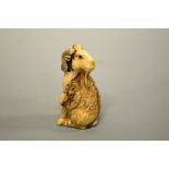 A JAPANESE IVORY NETSUKE, carved in the form of a Mountain Goat, signed to base