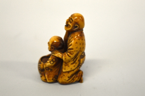 A JAPANESE BOXWOOD NETSUKE, carved as men at work, signed to base - Image 2 of 3