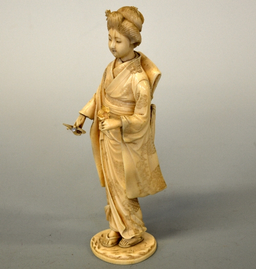 A JAPANESE IVORY OKIMONO, Meiji period, a Geisha holding secateurs and a flower, bears red seal mark - Image 2 of 2