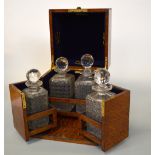 A MAPPIN & WEBB CASED OAK TANTALUS, opens to reveal four cut glass glass decanters, one is a