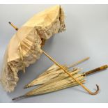 THREE LADIES PARASOLS, one with lace border and red inner fabric, bamboo handle, one with floral