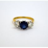 AN 18CT GOLD SAPPHIRE AND DIAMOND RING, the circular shape sapphire flanked by two brilliant-cut