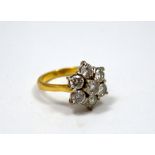 AN 18CT GOLD DIAMOND RING, designed in a flower shape, comprising of seven brilliant-cut diamonds