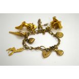 A CHARM BRACELET, the bracelet with heart shape padlock clasp with various novelty charms to include