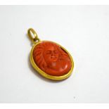 A CARVED CORAL CAMEO PENDANT, of whimsical woman in profile within yellow metal surround