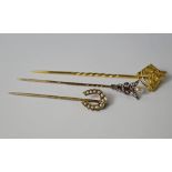 A diamond and pearl set caduceus stick pin, the snakes and wings set with old cut diamonds and