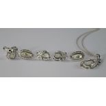 An 18ct white gold and mother of pearl parure, comprising pendant, earrings and ring, of leaf