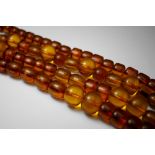 A long string of amber beads, a mixture of cushion shape, oval and tubular beads, approx 133cm,