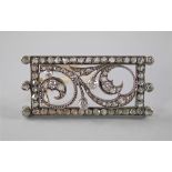 A French gold, silver and diamond set brooch, c.1920s, of rectangular form, the scrolled design