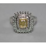 A 14ct white gold and fancy yellow diamond set ring, the central cushion cut natural fancy yellow