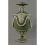 A Wedgwood sage green jasperware urn, 19th century, moulded with twin face handles, with classical