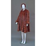 An impressive mahogany mink swing coat, with small collar, single neck button fastening and turn