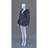 A dark mink jacket, 1980s, the collarless jacket with black leather trim, gilt metal button