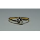 An 18ct yellow and white gold two stone diamond cross-over ring, each stone approx 0.10ct, approx
