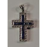 A 9ct white gold, sapphire and white stone set cross pendant, the channel set square cut sapphires