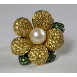 An 18ct white and yellow gold, yellow sapphire, tsavorite and pearl dress ring, of flower head form,