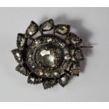A circular diamond set brooch, the central old mine cut stone approx 1ct, with rough cut stones