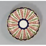A Worcester porcelain plate, circa 1780, the body of fluted form with rounded rim, with a gilt petal