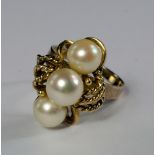 A 14ct gold and pearl ring, of knotted rope design, set with three cream cultured pearls, on plain