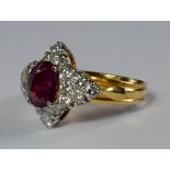 A ruby and diamond cluster ring, of star formation, the central oval cut ruby approx 1.0ct, set in
