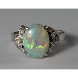 An 18ct white gold, opal and diamond set ring, the oval cabochon opal flanked by diamond set leaf