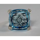 An unusual 18ct gold, blue stone and diamond set dress ring, the blue topaz colour stone of