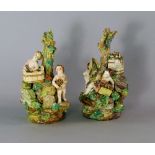 A pair of Derby porcelain centre pieces, 18th century, modelled as grounds of cherubs, on rocky