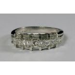A platinum and diamond set ring, the central band of square cut diamonds flanked either side by a
