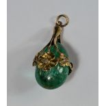 An Art Nouveau tear drop emerald pendant, c.1900, the emerald mounted in unmarked yellow metal in
