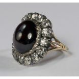 A Georgian garnet and diamond ring, the large cabochon garnet with a border of sixteen old cut