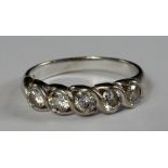 An 18ct white gold and five stone diamond ring, in scroll design mount, approx size P, approx 4.