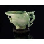 A Chinese mottled jade ewer, 19th/20th century, carved with a dragon handle, the body in low